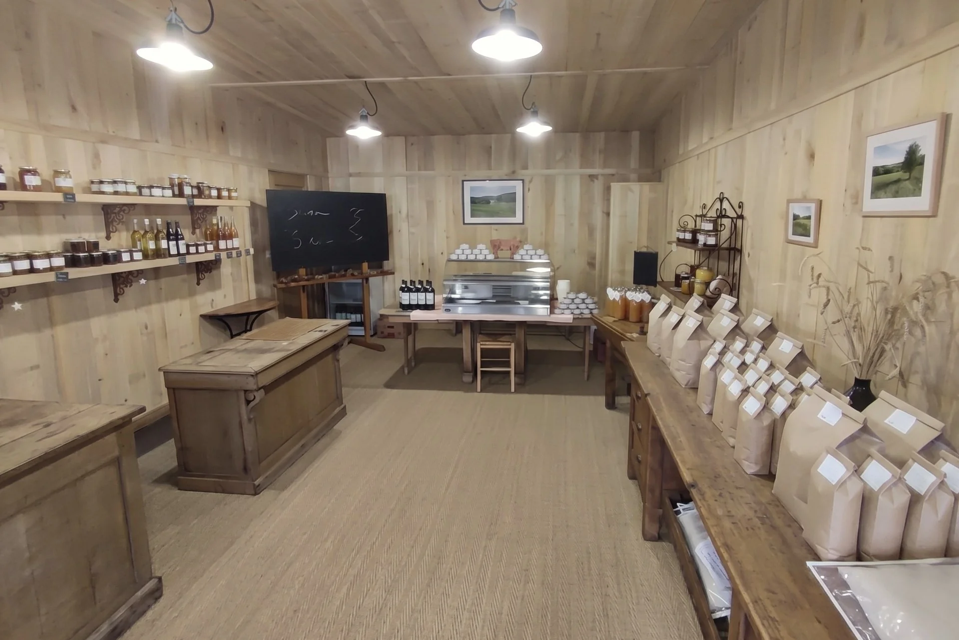 Illustration : une boutique à la ferme tout en bois, avec ses bocaux, sa vitrine réfrigérée et ses sacs de farine.